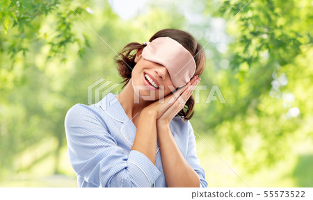 happy young woman in pajama and eye sleeping mask 55573522