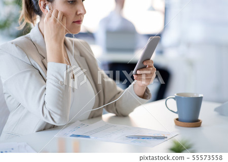 businesswoman with earphones and smartphone 55573558