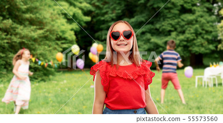 girl in heart shaped sunglasses at birthday party 55573560