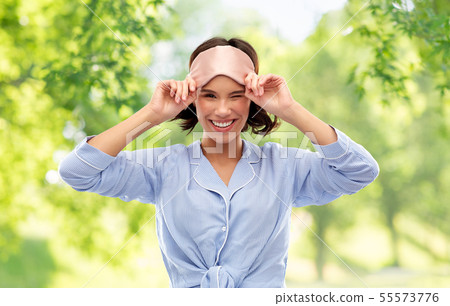happy young woman in pajama and eye sleeping mask 55573776