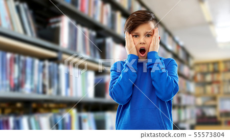 terrified boy over book shelves at library terrified boy over book shelves at library 55573804