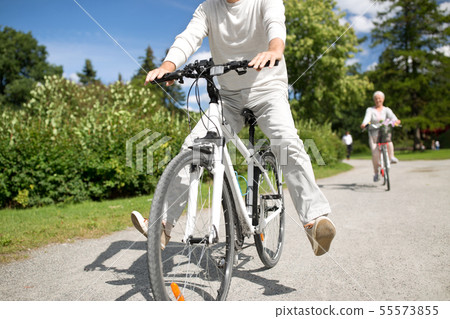happy senior man riding bicycle at summer park happy senior man riding bicycle at summer park 55573855