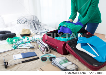 woman packing travel bag at home or hotel room 55574006