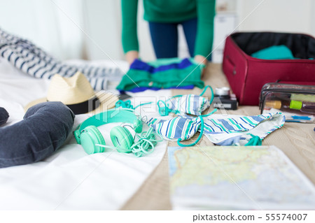 woman packing travel bag at home or hotel room 55574007