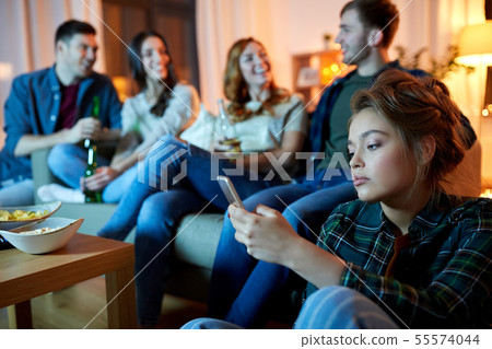 sad young woman with smartphone at home party 55574044