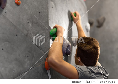 young man exercising at indoor climbing gym young man exercising at indoor climbing gym 55574045