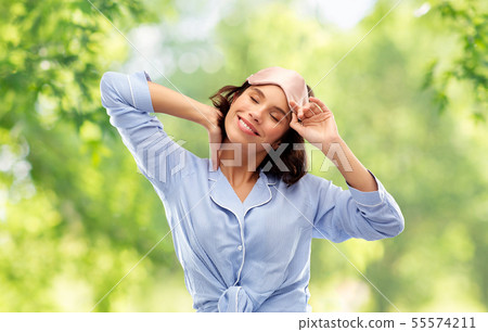 happy young woman in pajama and eye sleeping mask happy young woman in pajama and eye sleeping mask 55574211