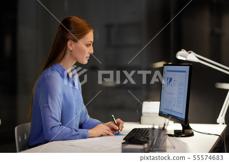 businesswoman at computer working at night office 55574683