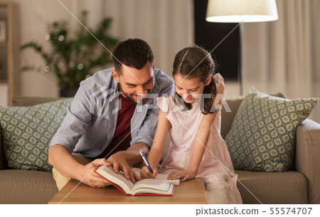 father and daughter doing homework together father and daughter doing homework together 55574707