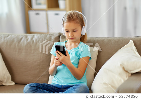 girl in headphones listening to music at home girl in headphones listening to music at home 55574850