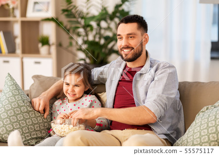 happy father and daughter watching tv at home 55575117