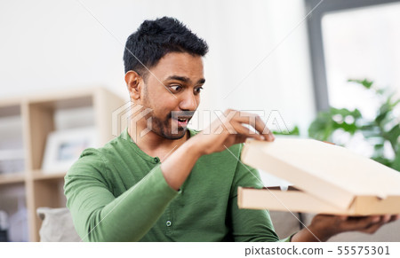 indian man looking inside of takeaway pizza box 55575301