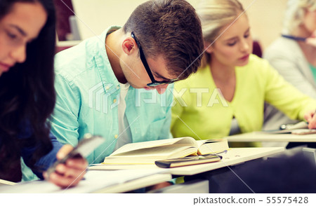 male student in glasses reading book at lecture male student in glasses reading book at lecture 55575428