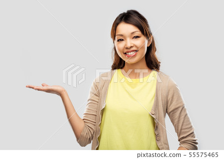 happy asian woman holding something on hand happy asian woman holding something on hand 55575465