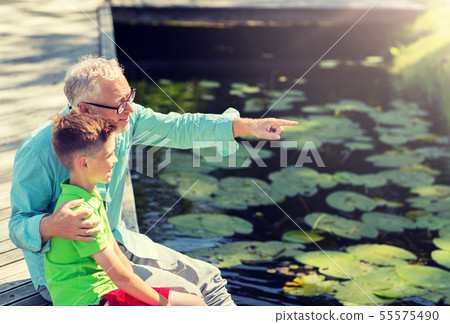 grandfather and grandson sitting on river berth 55575490