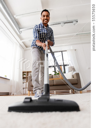 indian man with vacuum cleaner at home indian man with vacuum cleaner at home 55575650