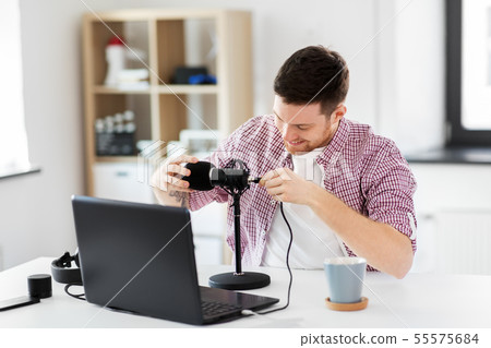 male audio blogger connecting cable to microphone 55575684