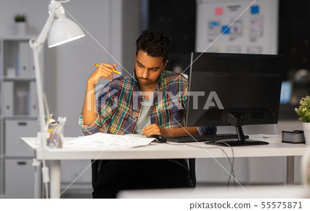 creative man with papers working at night office creative man with papers working at night office 55575871