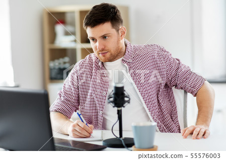 audio blogger with laptop, microphone and notebook 55576003