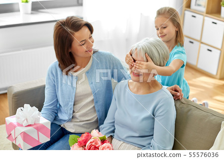 mother and daughter greeting grandmother at home mother and daughter greeting grandmother at home 55576036