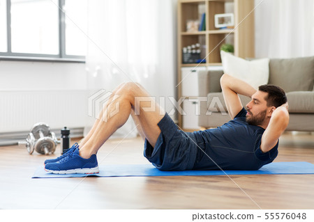 man making abdominal exercises at home 55576048