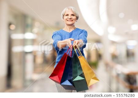 senior woman with shopping bags over mall senior woman with shopping bags over mall 55576280