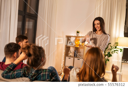 happy friends playing charades at home in evening happy friends playing charades at home in evening 55576312