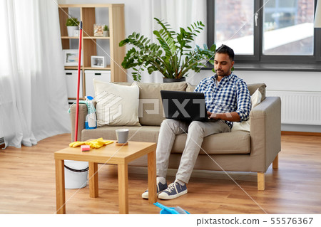 man with laptop computer after home cleaning man with laptop computer after home cleaning 55576367