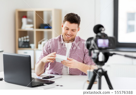 male blogger with camera videoblogging at home 55576388