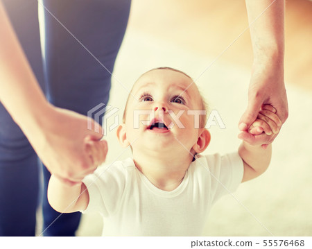 happy baby learning to walk with mother help 55576468