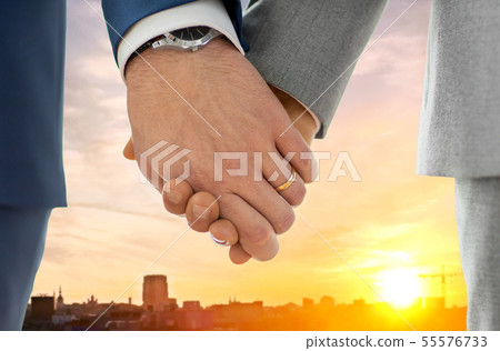 close up of male gay hands with wedding rings on 55576733