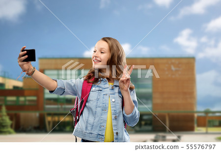 girl taking selfie by smartphone over school 55576797