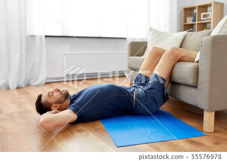 man making abdominal exercises at home man making abdominal exercises at home 55576978