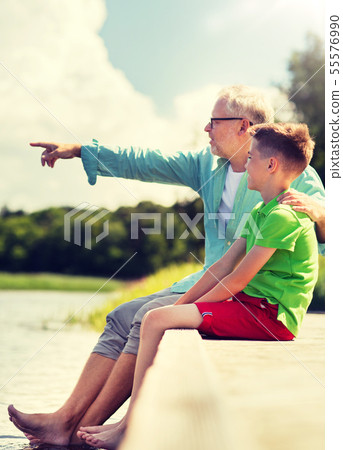 grandfather and grandson sitting on river berth 55576990