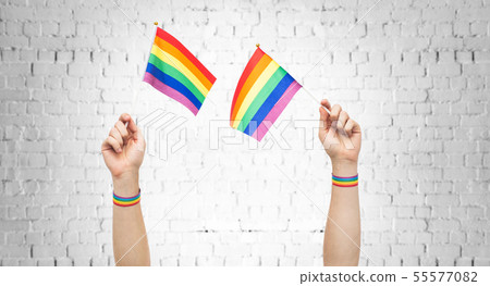 hands with gay pride rainbow flags and wristbands 55577082