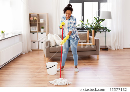african woman or housewife cleaning floor at home 55577182
