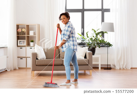 woman with sweeping broom brush cleaning floor woman with sweeping broom brush cleaning floor 55577200