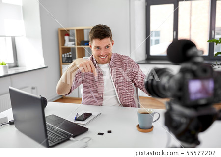 male blogger with camera videoblogging at home 55577202