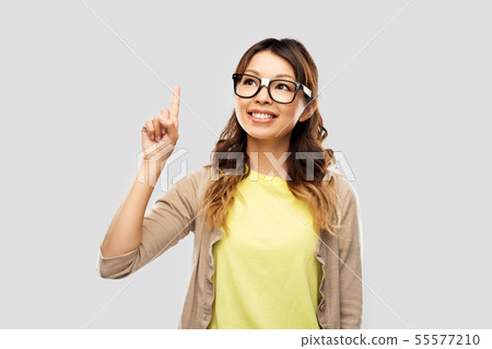 asian woman in glasses or student with finger up asian woman in glasses or student with finger up 55577210