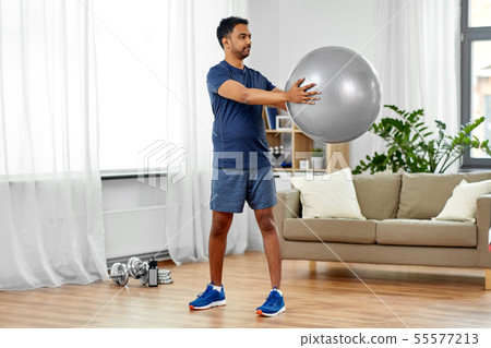 indian man exercising with fitness ball at home indian man exercising with fitness ball at home 55577213