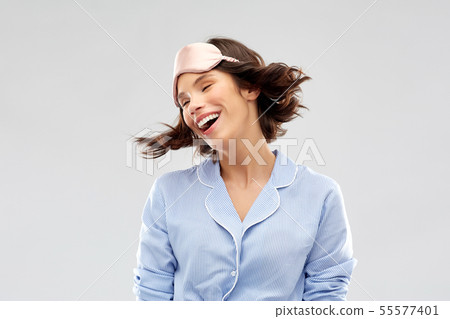 happy young woman in pajama and eye sleeping mask 55577401
