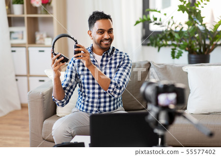 male blogger with headphones videoblogging at home 55577402