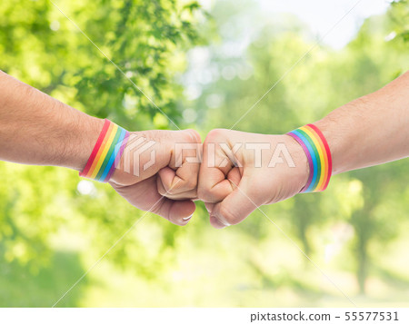 hands with gay pride wristbands make fist bump 55577531