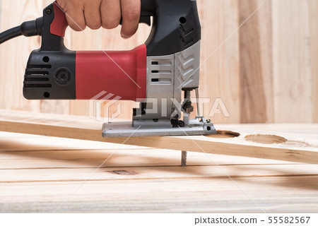 Electric jigsaw in male hand. Processing of 55582567