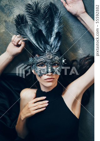 young beautiful woman in masquerade carnival mask lying on floor young beautiful woman in masquerade carnival mask lying on floor 55592882