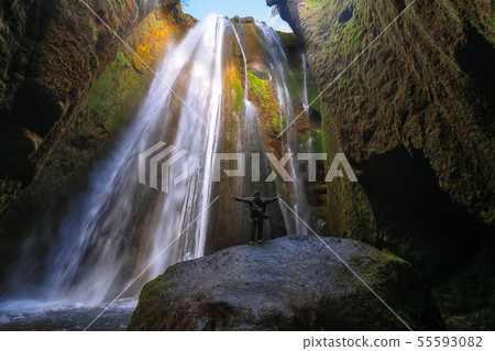 Traveler stunned by Gljufrabui waterfall cascade 55593082