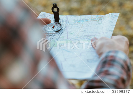 traveler lifestyle man compass map yellow grass traveler lifestyle man compass map yellow grass 55599377