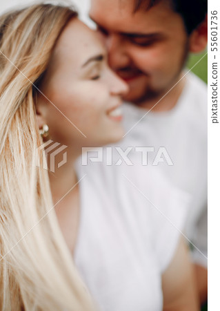 Beautiful couple spend time on a summer field Beautiful couple spend time on a summer field 55601736
