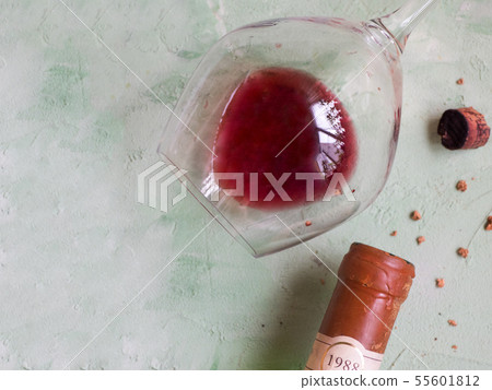 A glass of old wine, a bottle and a broken cork. A glass of old wine, a bottle and a broken cork. 55601812
