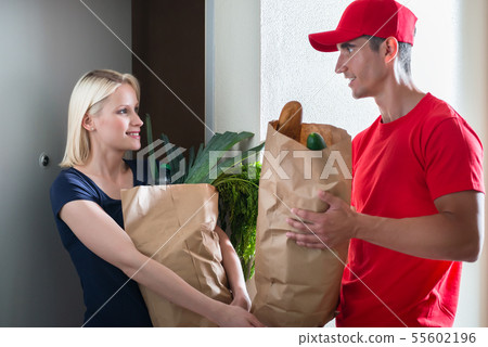 Female customer receiving the grocery delivery Female customer receiving the grocery delivery 55602196